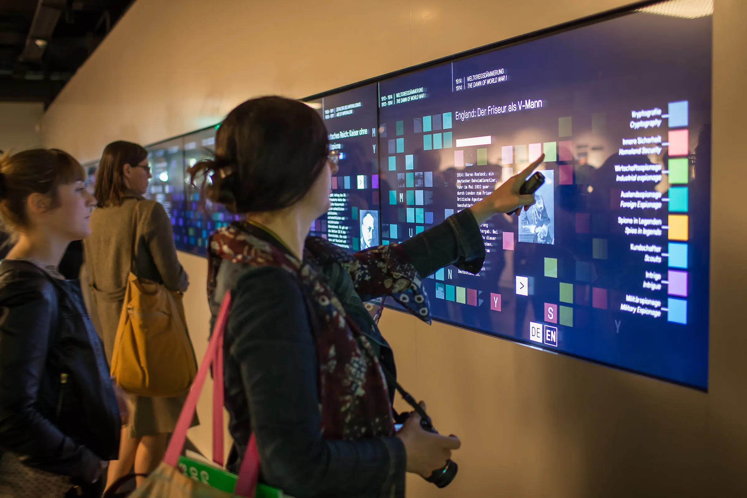 Museums-Besucherin berührt Multitouch-Wall im Deutschen Spionagemuseum